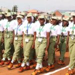 Nigerian students completing their NERD portal registration for NYSC mobilization on laptops.