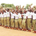 NYSC Corps Members standing outside their rented accommodation in a rural community in Nigeria.