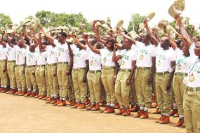 NYSC Corps Members standing outside their rented accommodation in a rural community in Nigeria.